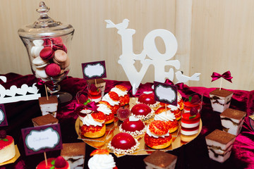 close-up of macaroons in vase and cupcakes. wedding reception.