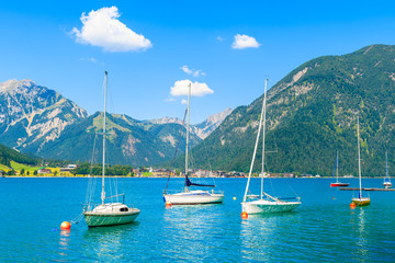 Fototapeta na wymiar Sailing boats and view of beach near Pertisau town at beautiful Achensee lake on sunny summer day, Tirol, Austria