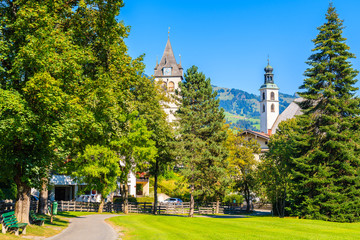 Church towers in Kitzbuhel town park against sunny blue sky in summertime, Tirol. Austria