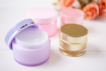 cosmetic and skin care product and flower on white wood table, beauty with treatment cream and moisturizing on wooden desk, health and wellness concept.