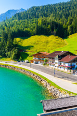 Shore of beautiful Achensee lake with houses on sunny summer day with blue sky, Karwendel mountain range, Tyrol, Austria