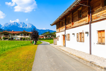 Fototapeta na wymiar Road in countryside landscape near Kitzbuhel town and view of alpine houses, Tirol, Austria