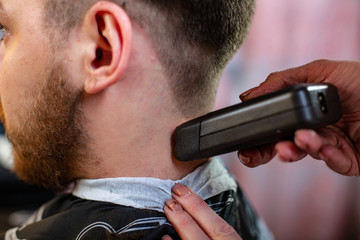 Close up of a male student having a haircut with hair clippers