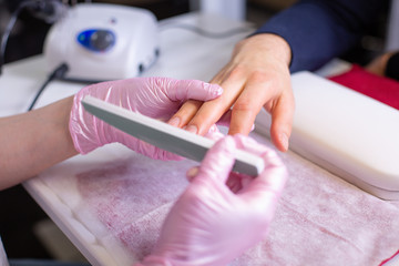 Professional manicure of male hands in a beauty salon close up. Master in gloves makes a manicure using modern technologies. Beauty concept of personal care, health, hand care.