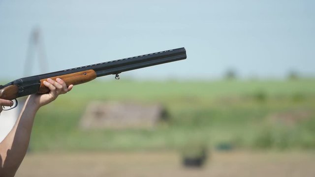Way-out over and under gun shooting clay pigeons on a big range in slow motion  