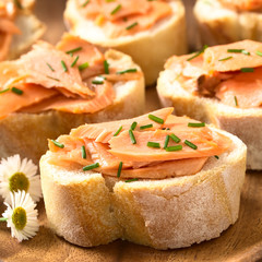 Smoked salmon sandwiches with chives, photographed with natural light (Selective Focus, Focus on the front of the salmon on the first bread)