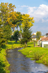 Slavkovsky potok stream flows through the Velky Slavkov village, Poprad district, Slovakia. High Tatras mountains on the background