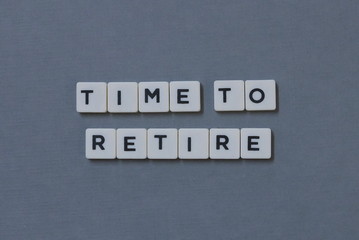 ' Time To Retire ' word made of square letter word on grey background.