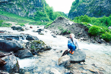 young smiling woman posing happy at mountain river on the rock, lifestyle people on vacation concept