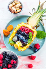 Gefüllter ananas mit waldbeeren und yogurt