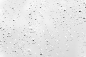 Water drops on glass white gray background.