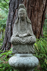 Fototapeta na wymiar Asian statue in garden setting