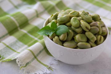 Boiled green beans on plate. Close up of boiled green beans on plate healthy and vegan dish with leaf of basil