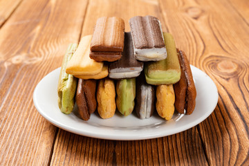 side view multicolor sandwich cookies on a wood table