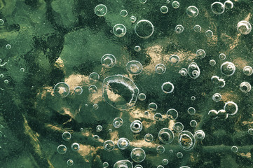 Texture abstract closeup background ice with grooves, furrows, and bubbles of air cought by frost in the mass of water while freezing