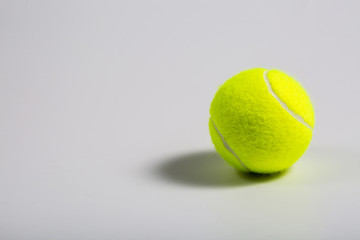 White background, yellow-green tennis ball closeup