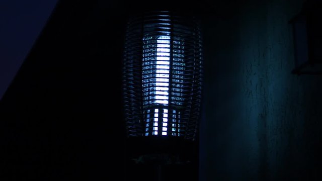 Bug Zapper at Night Electrocuting Insects Wide Shot
