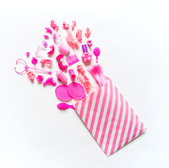 Girly toys for the baby in the pink package. Accessories for dolls. Flat lay