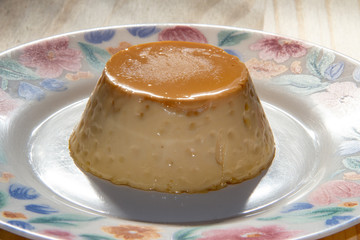 Pudim de leite individual no prato com sombras