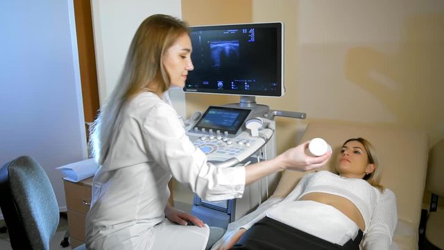 Doctor puts medical gel. She Taking A Sonogram a stomach the woman