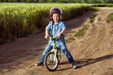 Portrait of a little boy on a Bicycle . The child wears a helmet . Summer walks in the fresh air