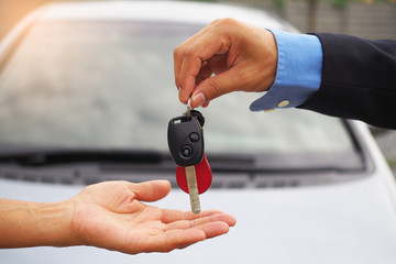 The car salesman and the key to the new owner.