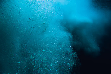 Wave underwater with air bubbles. Blue crystal ocean in underwater