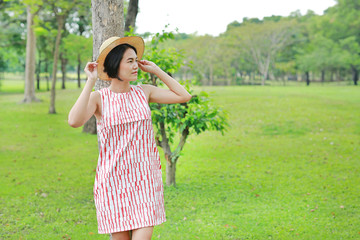 Fototapeta premium Beautiful young asian woman poses in the nature park.