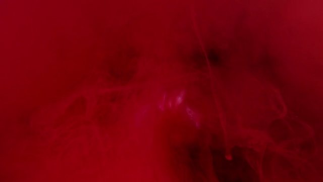Red colour cloud smoke - ink on the water on black background. Camera fixed, angle neutral, close up shoot, slow motion. (TOKYO, JAPAN - 10th May 2019).