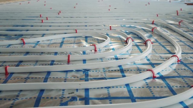 Underfloor heating pipes are laid on a special surface, installation of a heating system