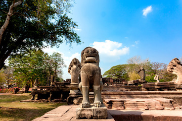 Fototapeta na wymiar Lion sandstone statue guarding the ruins of the temple in the Phimai Historical Park . Nakhon Ratchasima, Thailand. -