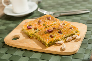 Traditional turkish and arabic dessert baklava with walnuts and pistachios Homemade  baklava on wooden plate and turkish cofffe served at bayram