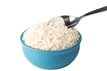 Blue plate full of rice with a metal spoon with rice isolated on white