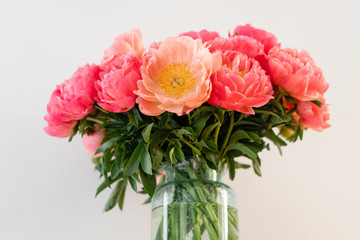 Coral peonies in a glass vase on wooden table.. Beautiful peony flower for catalog or online store. Floral shop concept . Beautiful fresh cut bouquet. Flowers delivery. Copy space