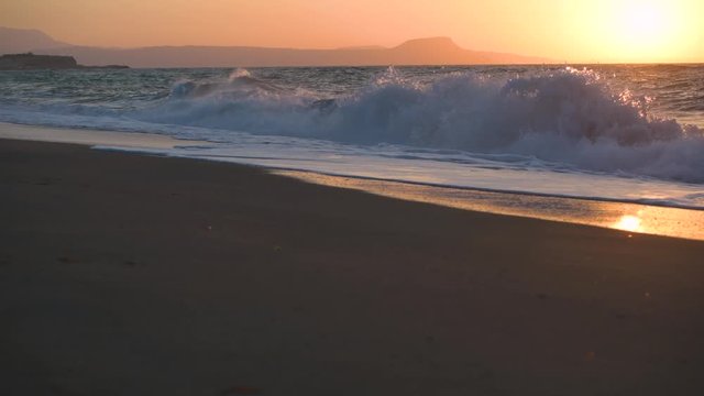 Sunset view seaside sea with waves in Crete Greece sun falling into the sea