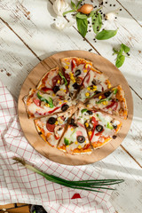 home made gourmet thin tortilla pizza on wooden plate and wood table gourmet food