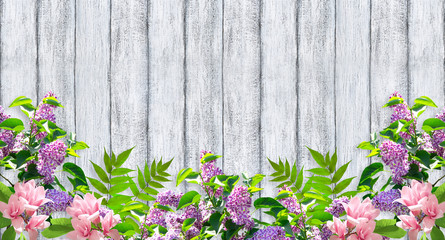 Fototapeta na wymiar Magnolia flowers and lilac on wooden wall background in shabby chic style and place for your photo or text. Floral garland. Copy space.