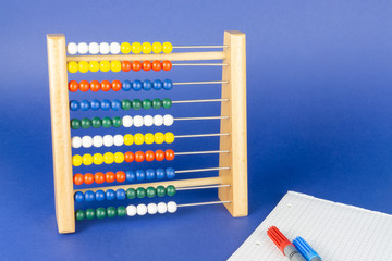 A slide rule with colorful balls, blue background and copy space