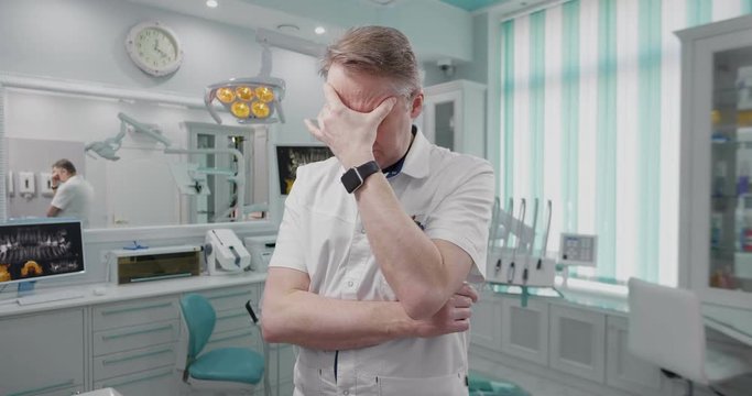 doctor is tired after work day and has headache.