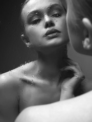 Reflection of Beautiful Girl in wet mirror. Black and white