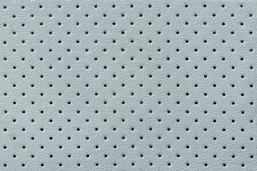 Perforated light blue leather texture background, closeup. backdrop from wrinkle skin.