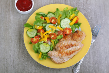 Grilled chicken breast with raw vegetables salad