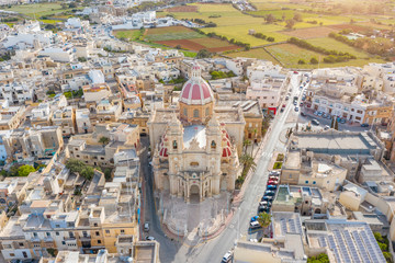 Fototapeta premium Zabbar Parish Church on the island of Malta, aerial view above, around typical houses buildings.