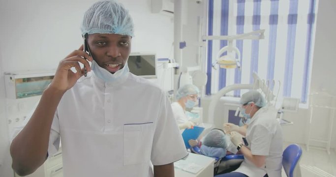 black dental assistant talks on phone in office