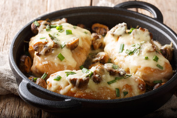 Fototapeta na wymiar Baked chicken breast with mushrooms, green onions, mozzarella and parmesan close-up in a pan. horizontal