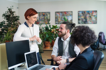 Group of young businesspeople using laptop in office, start-up concept.