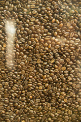 Naklejka premium Roasted coffee beans texture under the glass