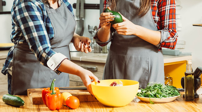 Midsection of women making salad. Healthy balanced eating habit vegan lifestyle. Females dieting preparing fresh veggies.