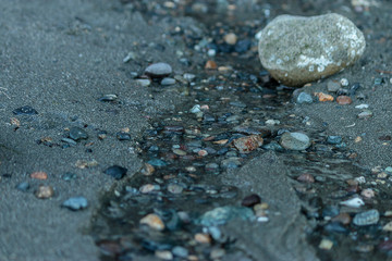 pebbles in a trickle of water on a beach