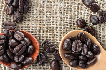 Coffee beans in wooden spoon. Close up macro photography.